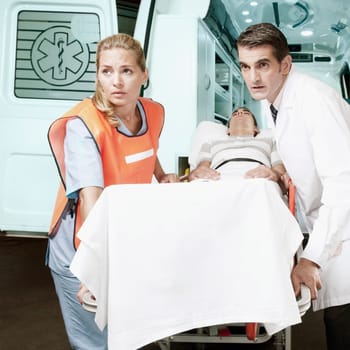 Paramedics pushing a patient on a gurney from an ambulance