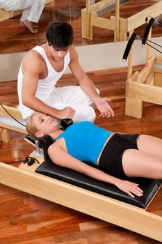 Male instructor assisting a woman in a gym