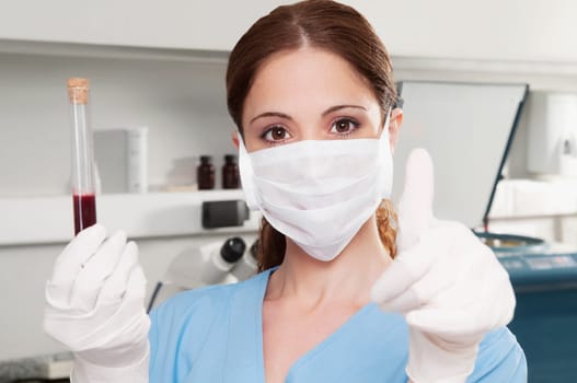 Female lab technician showing thumbs up sign in a laboratory