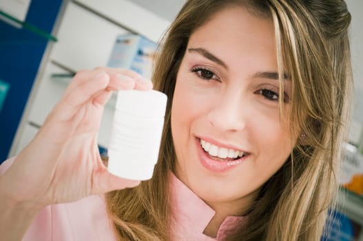 Female pharmacist holding a medicine bottle