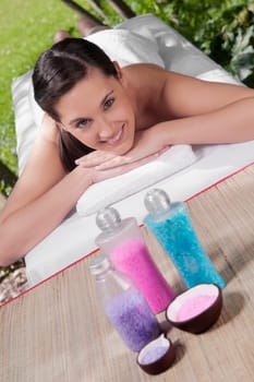 Portrait of a woman lying on a massage table with bath salt