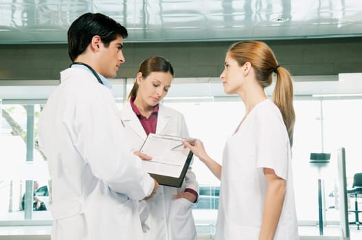 Three doctors discussing a report
