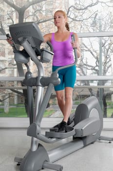Woman working out on a stepping machine in a gym