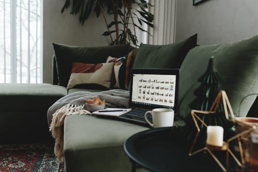 Laptop on the green sofa. Work from home. Loft or modern interior. High quality photo