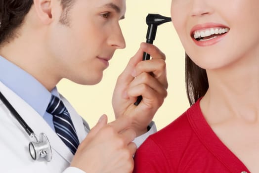 Doctor examining a womanŽs ear with an otoscope