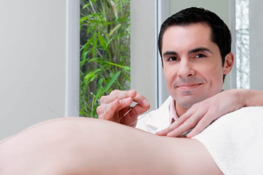 Acupuncturist applying needles on a personŽs back