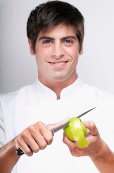 Man peeling a granny smith apple and smiling