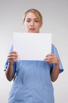 Female nurse holding blank placard