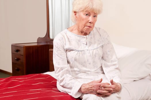 Woman sitting on the bed and looking serious