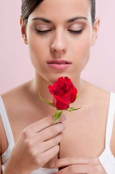 Close_up of a woman smelling a rose
