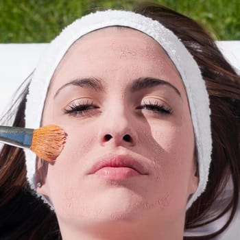 Woman applying a facial mask