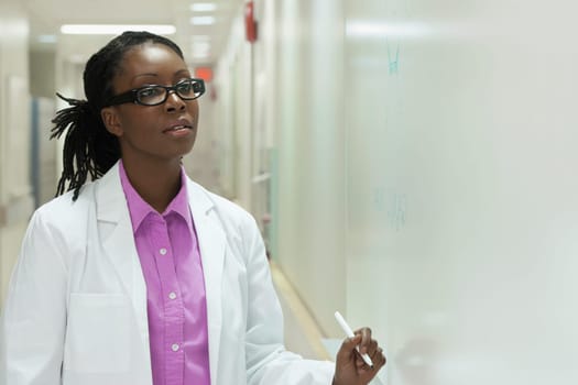 Female doctor writing on a whiteboard in a hospital