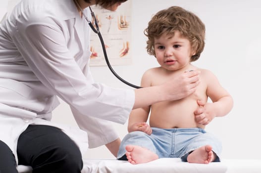 Female doctor examining a baby boy with a stethoscope