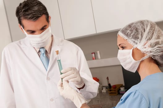 Lab technicians analyzing a sample in a test tube