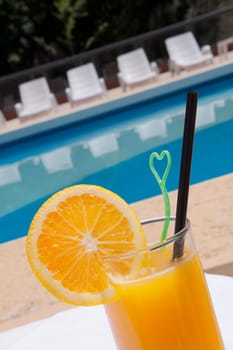 Glass of orange juice at the poolside