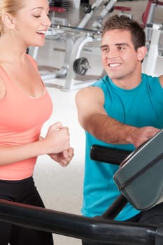 Man assisting a woman on a treadmill