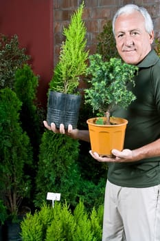 Man holding potted plants in a greenhouse