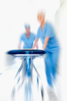 Two doctors pushing a gurney in a hospital corridor