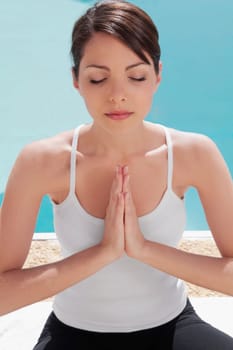 Woman practicing yoga at the poolside