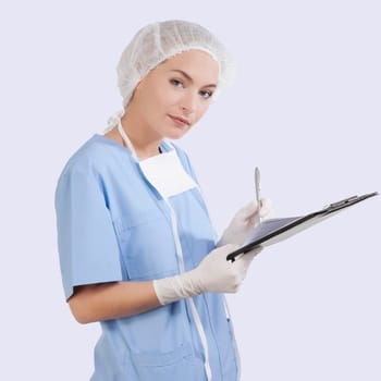 Female surgeon writing on a clipboard