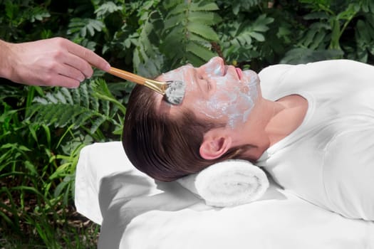 Beautician applying facial mask on a manŽs face