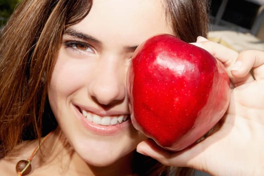 Portrait of a woman showing an apple