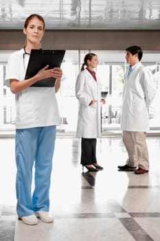 Female doctor with her colleagues in the background