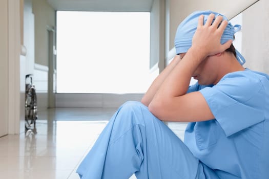 Surgeon sitting on the floor looking depressed