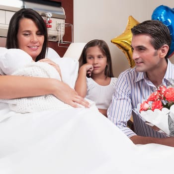 Couple with their newborn baby in a hospital