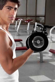 Portrait of a man exercising with dumbbell in a gym