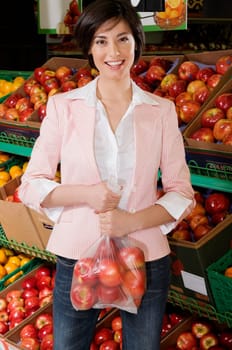 Woman buying apples in a supermarket