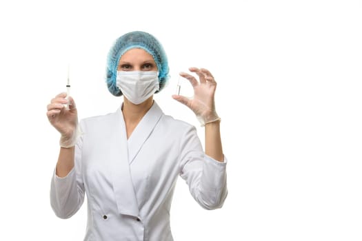 The doctor holds a syringe in one hand in the other ampoule with a medicine looks into the frame