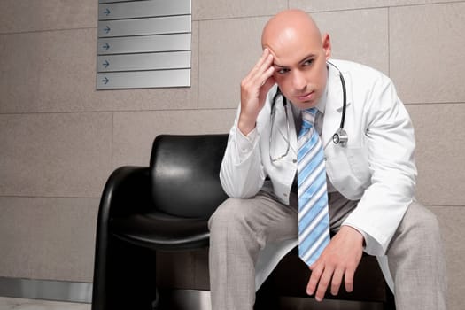 Doctor sitting on a chair and looking stressed