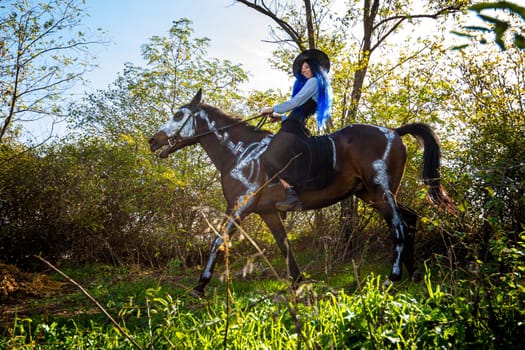 Girl dressed as a witch riding a horse in halloween celebration