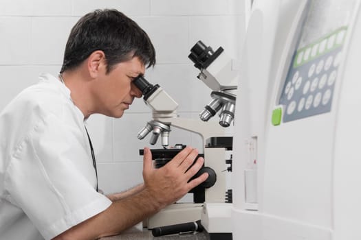 Vet looking into a microscope