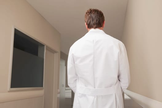 Rear view of a doctor standing at the corridor