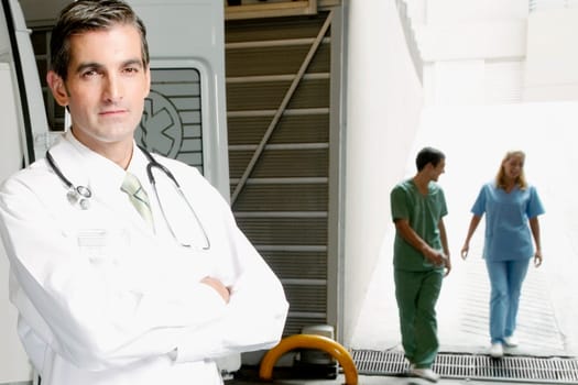 Portrait of a doctor with nurses in the background