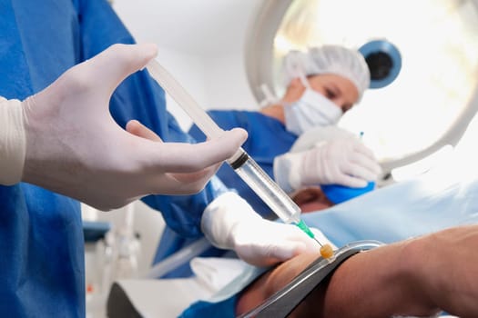 Doctor injecting patientŽs arm in an operating room