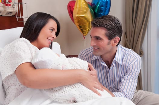 Couple with their newborn baby in a hospital