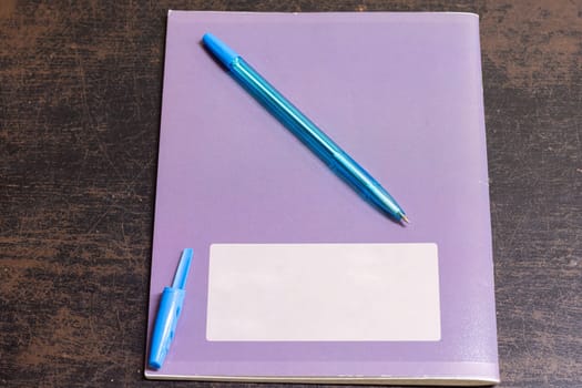 On the old table is a notebook and a pen with an open cap