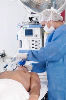 Female surgeon anesthetizing a patient in an operating room