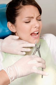 Dentist using pliers to pull out womanŽs teeth