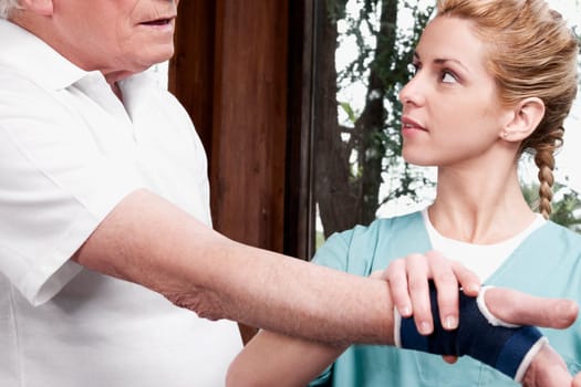 Health worker putting on a wrist brace to a disabled man