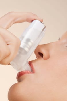 Close_up of a woman using an inhaler