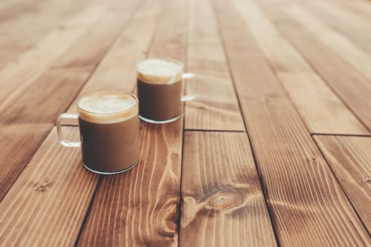 Two cups of coffee in the wooden brown terrace background. High quality photo