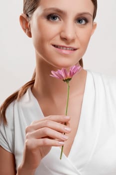 Portrait of a woman holding a flower and smiling