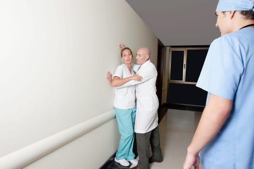 Male doctor flirting with a female nurse in the hospital corridor