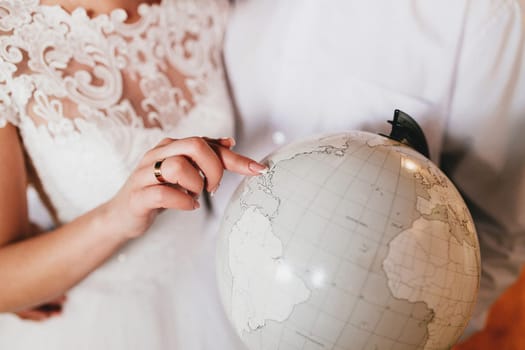 Bride is showing place on the globe. High quality photo