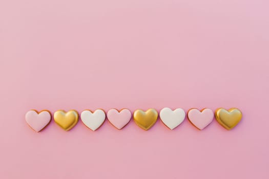 Pink background with sweet gingerbread heart cookies. High quality photo