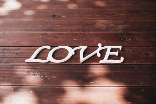 White word love on the brown wood. High quality photo